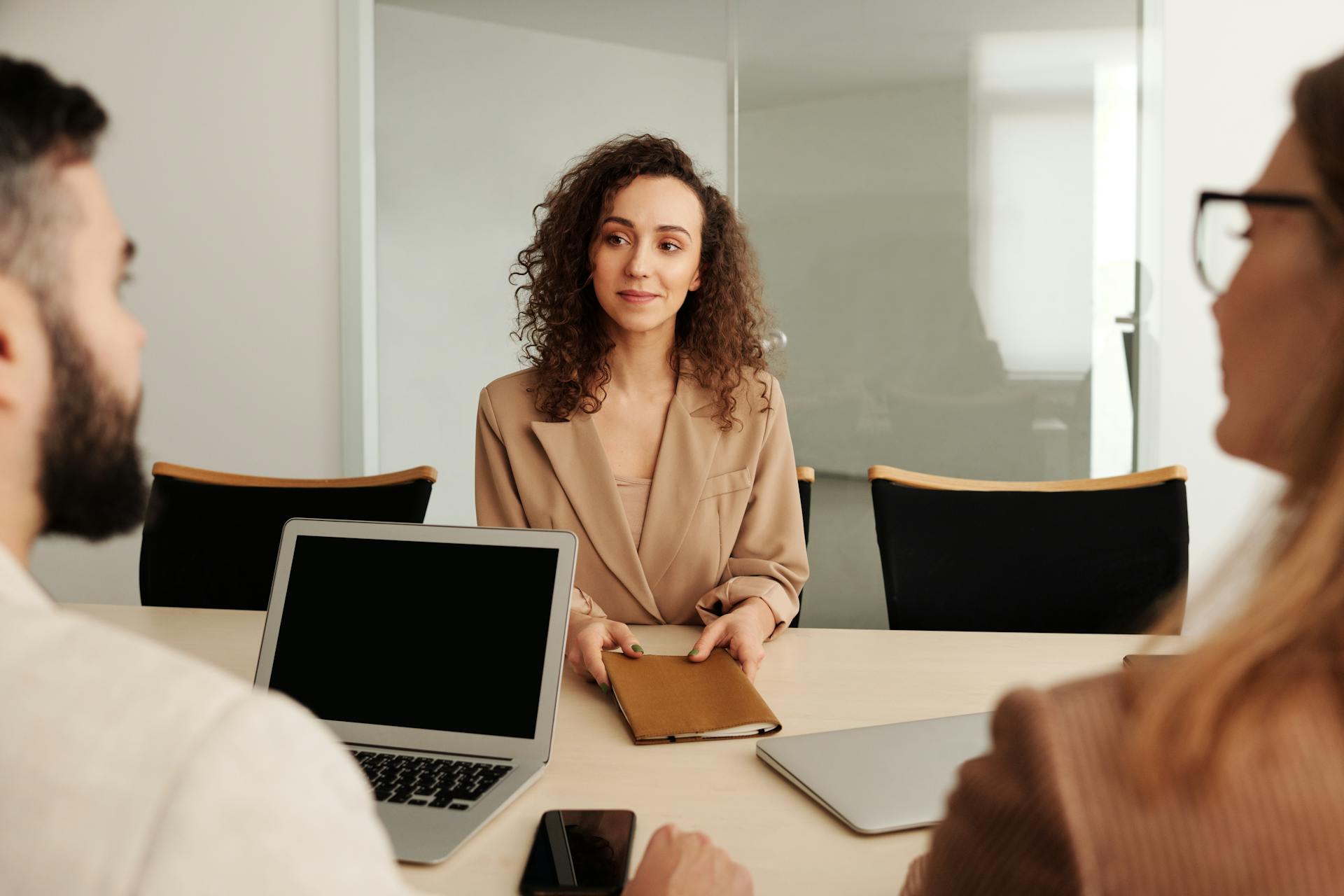 A candidate confidently attending a job interview across a boardroom table, representing CareHubSupport's welcoming recruitment process for nurses, care assistants and support workers